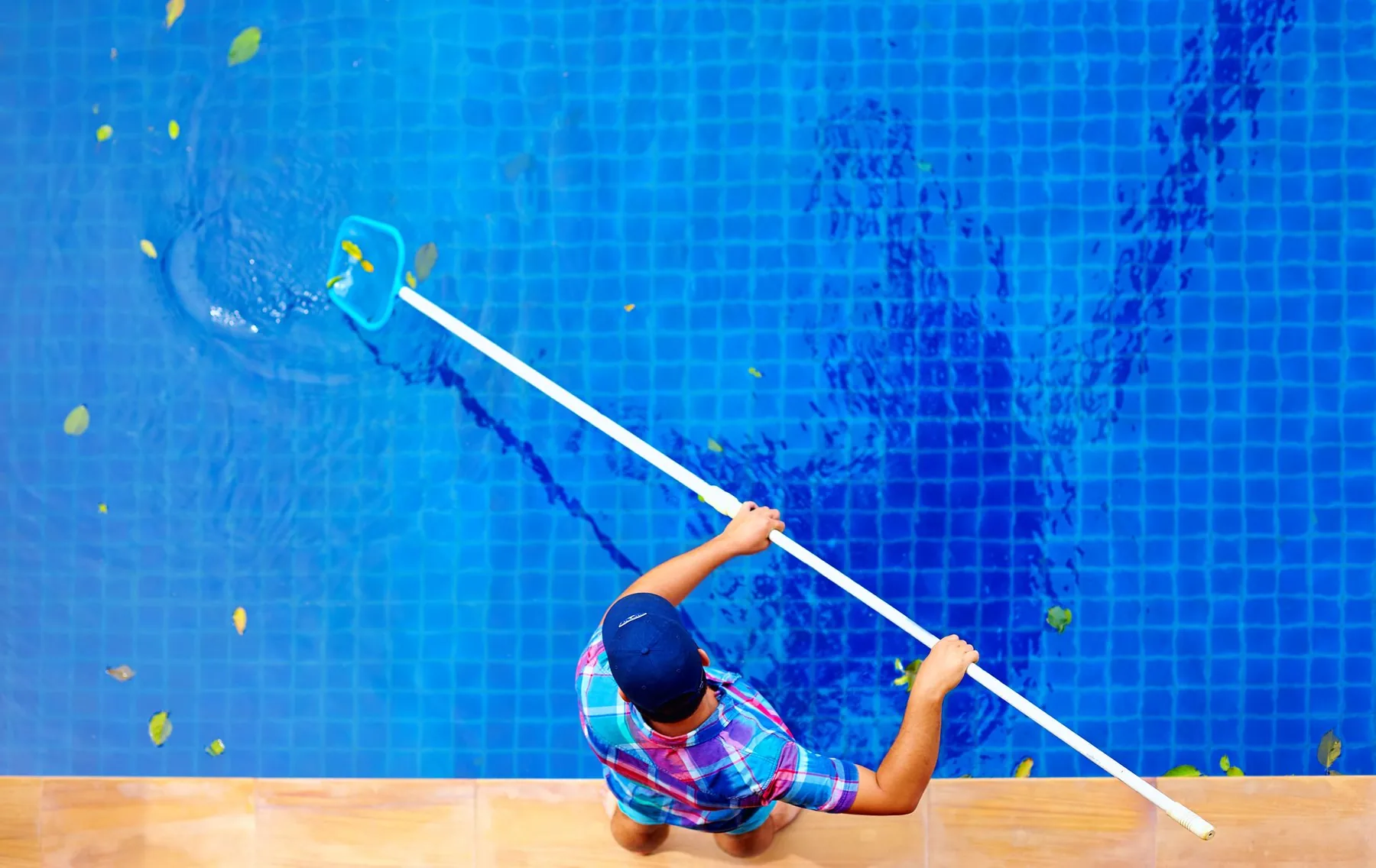 Man cleaning a pool to keep up the maintenance