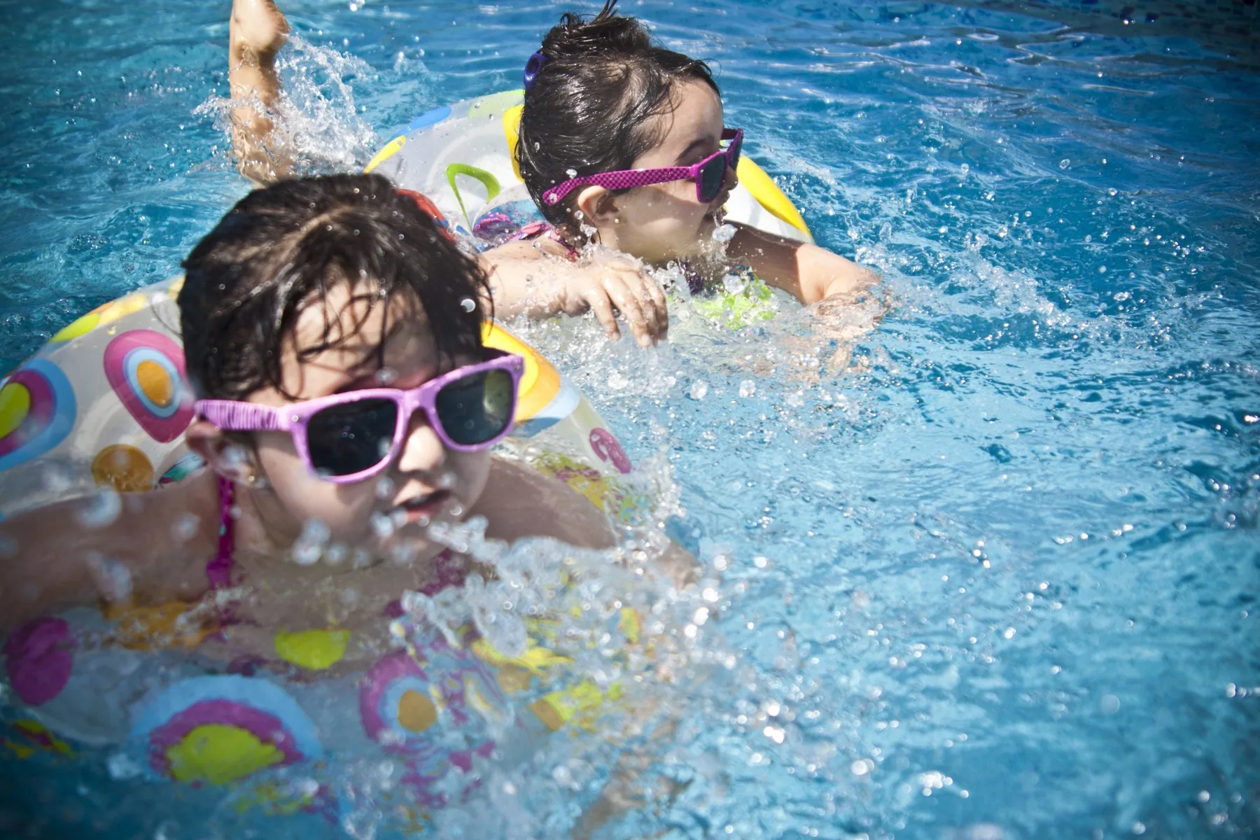 Kids in floaties swimming in a family pool